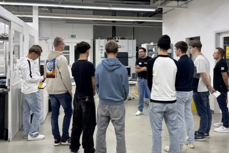 Gruppe von Jugendlichen bei einer Fuehrung durch die Mechatronik-Produktion